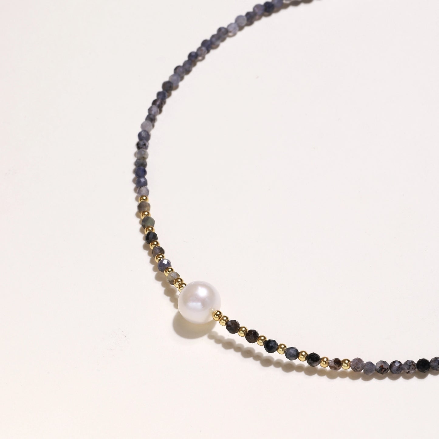 Dainty necklace with faceted purple iolite beads, gold vermeil accents, and central pink-white freshwater pearl.