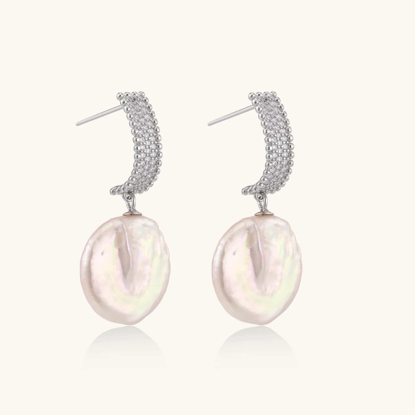 Rhodium-plated silver curved stud with pave stones and baroque pearl drop on white background