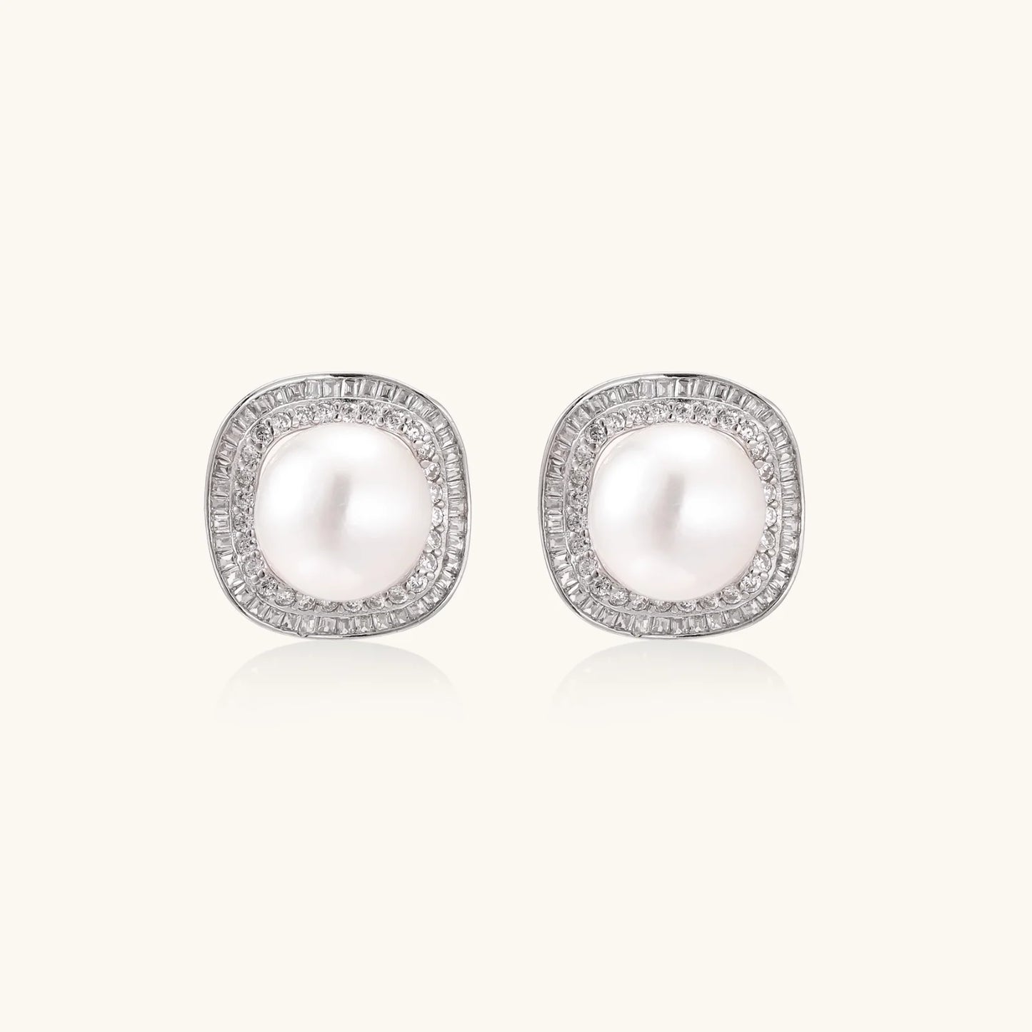 Cushion-shaped sterling silver stud earrings with freshwater pearls surrounded by geometric diamond halos