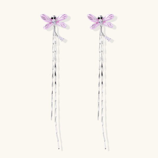 Long drop earrings with translucent lavender enamel dragonfly wings and white gold plated segmented bodies on white background