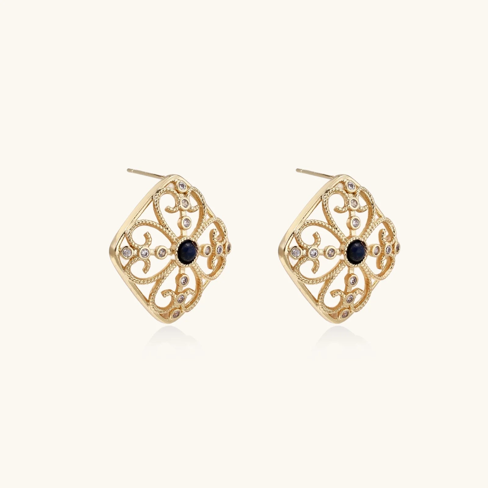 Gold filigree stud earrings with navy lapis lazuli center stone and mother-of-pearl accents in ornate quatrefoil design