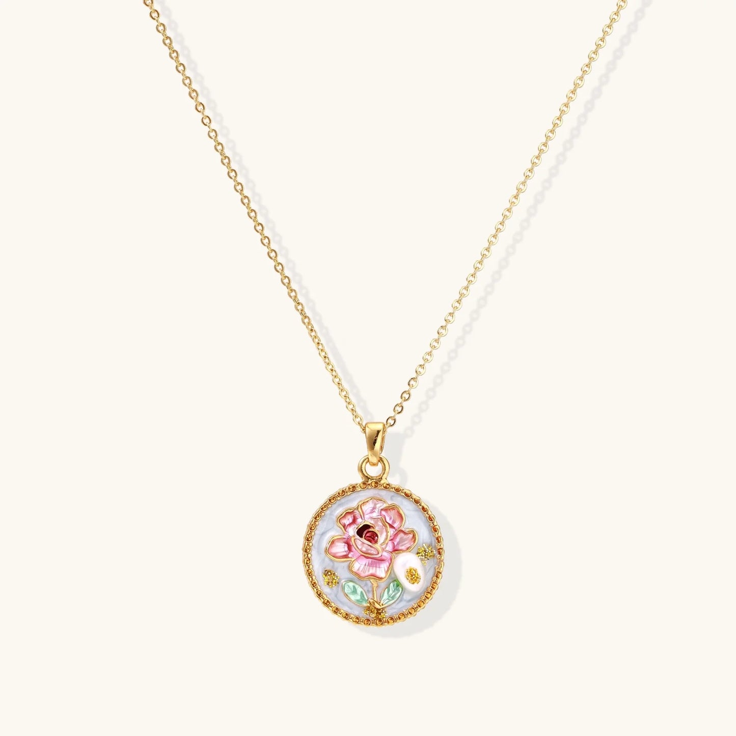 Gold-plated circular pendant with pink enamel rose, pearl background, and delicate beaded border on chain