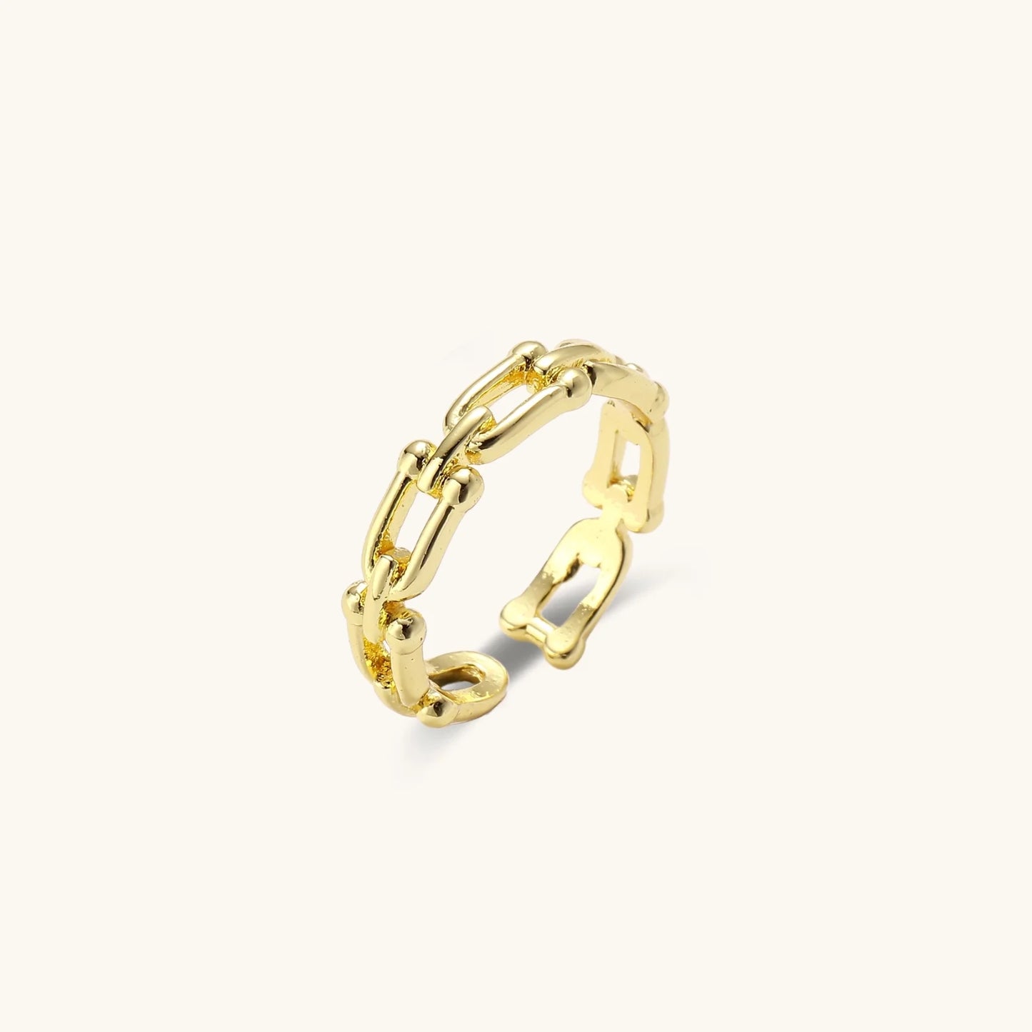 Two adjustable gold rings: chain-link band and halo-style ring with cubic zirconia stones on cream background
